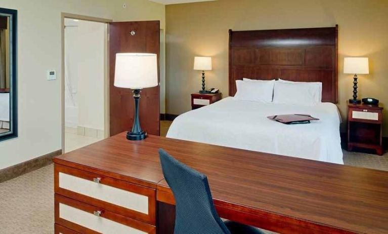 Delux king-sized bed with work desk at Hampton Inn & Suites Ocean City/Bayfront-Convention Center.