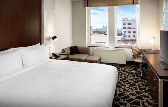 king-sized bed with desk at Hilton Brooklyn New York.