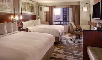 Stylish bedroom with two queen size beds, desk and TV screen at the Hilton Denver City Center.