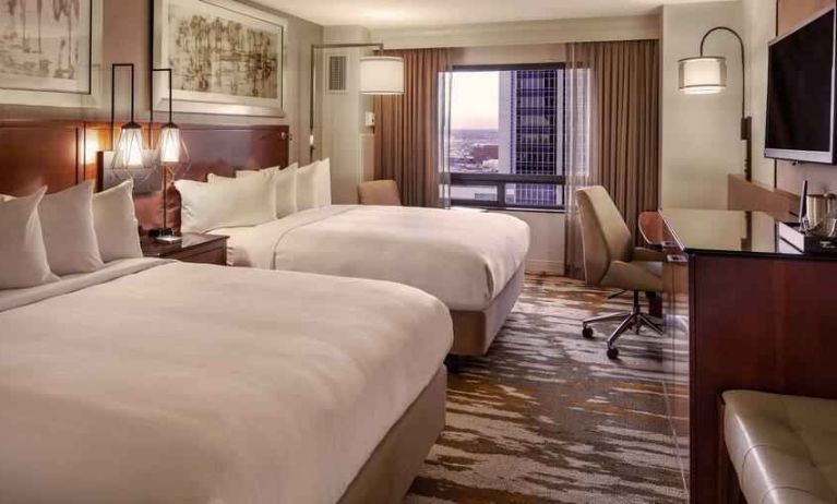 Stylish bedroom with two queen size beds, desk and TV screen at the Hilton Denver City Center.