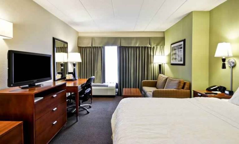 Spacious and bright king guestroom with a large window at the Hampton Inn Chicago-Gurnee.