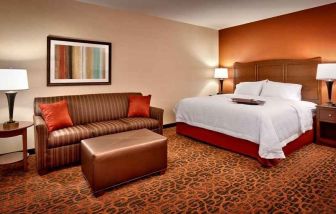 spacious king-sized bed with lounge area at Hampton Inn Omaha/West-Dodge Road (Old Mill).