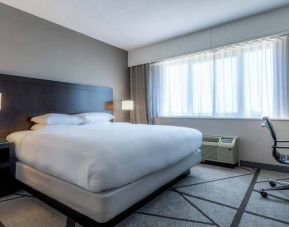 king-sized bed equipped with TV and work desk and with natural light at DoubleTree by Hilton Los Angeles - Norwalk.