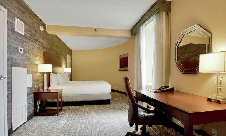 Desk and king size bed in a hotel room at the DoubleTree Suites by Hilton Houston by the Galleria.