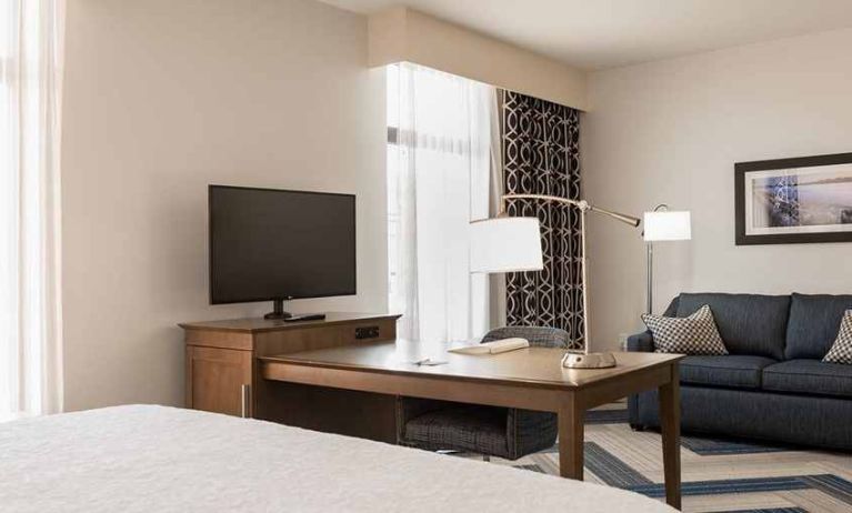 king-sized bed in studio with work desk, TV, and lounge area at Hampton Inn & Suites La Crosse Downtown, WI.