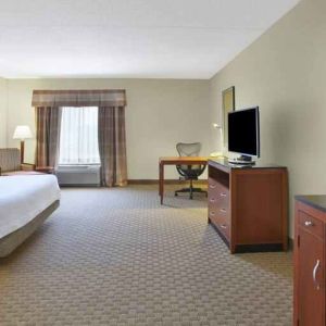 Spacious and bright king guestroom with TV and desk at the Hilton Garden Inn Clarksburg.