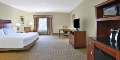 Spacious and bright king guestroom with TV and desk at the Hilton Garden Inn Clarksburg.