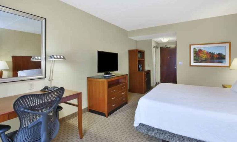 King size bed, desk and TV screen in a hotel room at the Hilton Garden Inn Clarksburg.