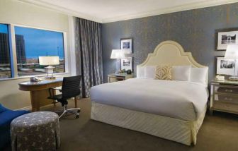 King size bed, large window and desk in a hotel room at the Hilton Dallas Lincoln Centre.