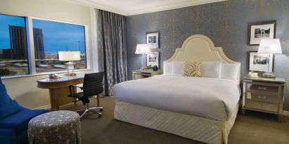 King size bed, large window and desk in a hotel room at the Hilton Dallas Lincoln Centre.