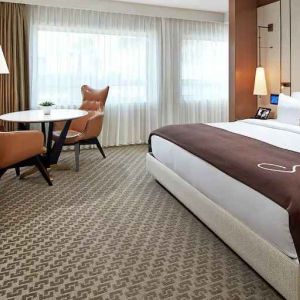 Comfortable king deluxe room with desk and window at the Statler Dallas, Curio Collection by Hilton.