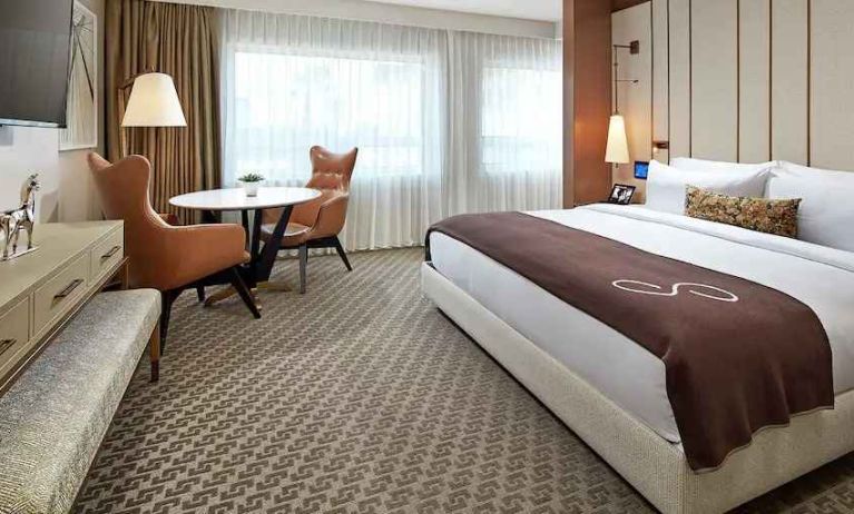 Comfortable king deluxe room with desk and window at the Statler Dallas, Curio Collection by Hilton.