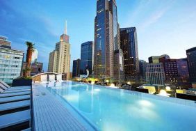 Relaxing outdoor pool with skyline view at the Statler Dallas, Curio Collection by Hilton.