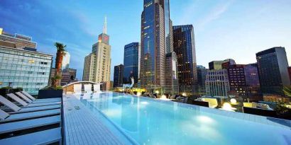 Relaxing outdoor pool with skyline view at the Statler Dallas, Curio Collection by Hilton.