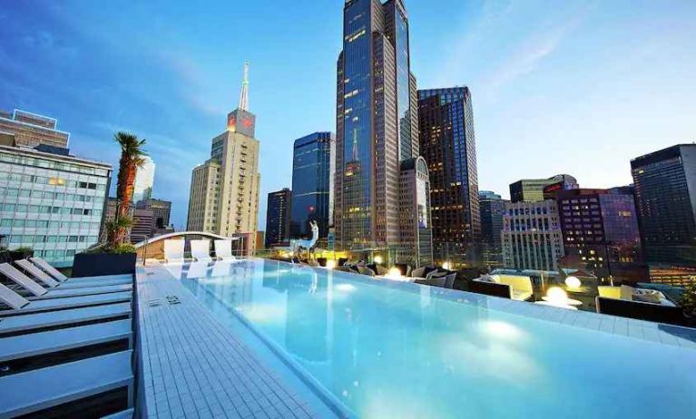 Relaxing outdoor pool with skyline view at the Statler Dallas, Curio Collection by Hilton.