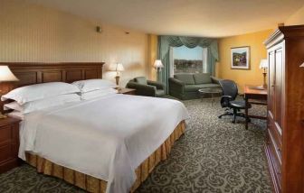 Spacious king room with king size bed, sofa and desk at the DoubleTree by Hilton Lisle-Naperville.