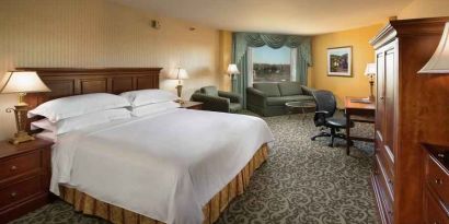 Spacious king room with king size bed, sofa and desk at the DoubleTree by Hilton Lisle-Naperville.