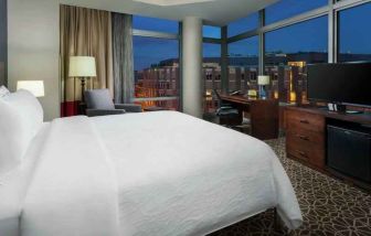 King size bed, sofa and desk in a hotel room with view at the Hilton Garden Inn Washington DC/Georgetown Area.