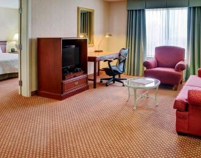 1 king bed with a couch and tv at the Hilton Garden Inn Kitchener/Cambridge