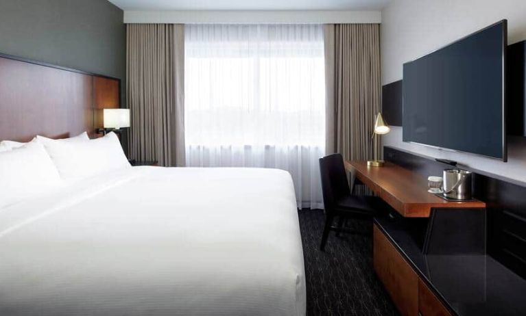 1 king bed room with tv and chair at the DoubleTree by Hilton Montreal Airport