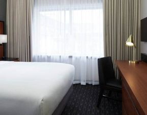 1 queen bed room with tv and chair at the DoubleTree by Hilton Montreal Airport