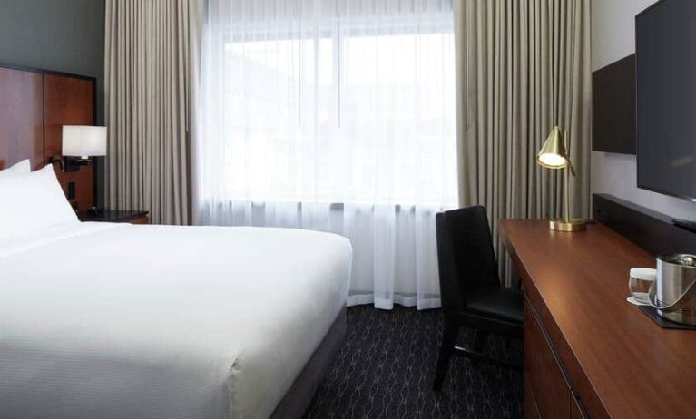 1 queen bed room with tv and chair at the DoubleTree by Hilton Montreal Airport