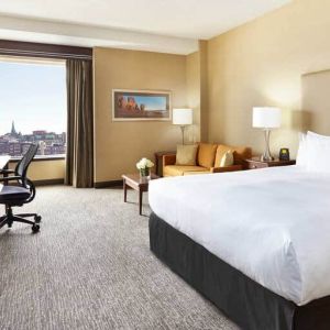 King room with 1 king bed, desk,chair and view of downtown at the Hilton Saint John