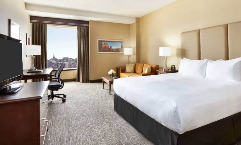 King room with 1 king bed, desk,chair and view of downtown at the Hilton Saint John