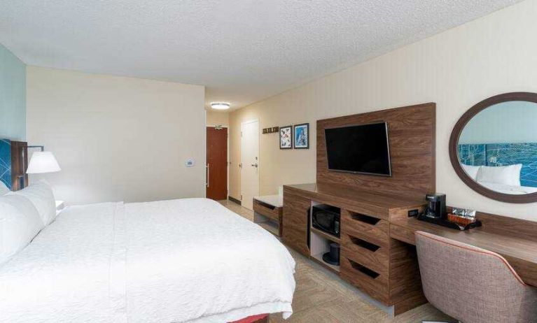 King size bed, desk and TV screen at the Hampton Inn & Suites West Little Rock.