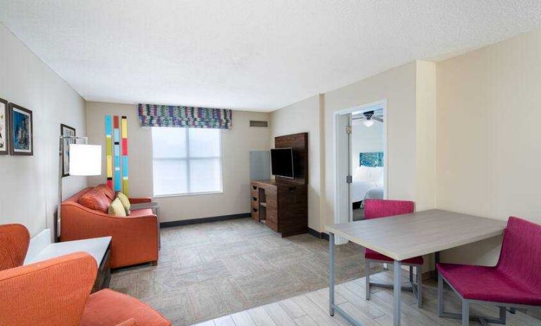 Spacious living room with working station in a king suite at the Hampton Inn & Suites West Little Rock.