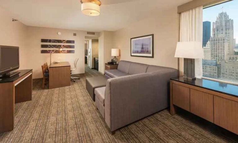 Spacious living room with working station in a king suite at the Embassy Suites by Hilton Chicago Magnificent Mile.