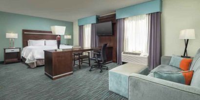 Spacious hotel suite with king size bed and working station at the Hampton Inn & Suites Schererville.