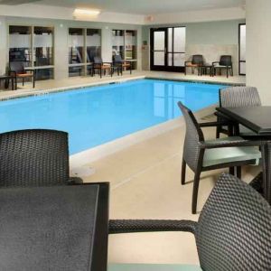 Relaxing indoor pool area with tables and chairs at the Hampton Inn & Suites Schererville.