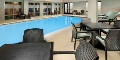 Relaxing indoor pool area with tables and chairs at the Hampton Inn & Suites Schererville.