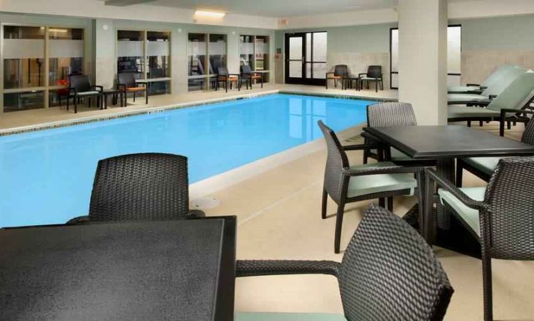 Relaxing indoor pool area with tables and chairs at the Hampton Inn & Suites Schererville.