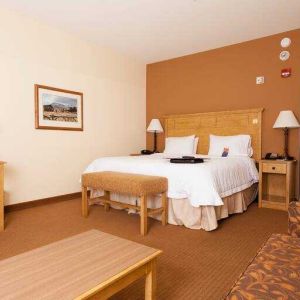 Spacious king suite with sofa and desk at the Hampton Inn & Suites Riverton, WY.