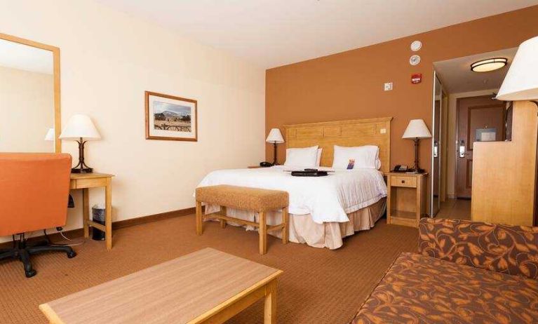 Spacious king suite with sofa and desk at the Hampton Inn & Suites Riverton, WY.