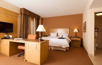 Hotel room with king size bed and working station at the Hampton Inn & Suites Riverton, WY.