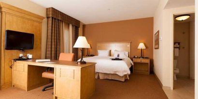 Hotel room with king size bed and working station at the Hampton Inn & Suites Riverton, WY.