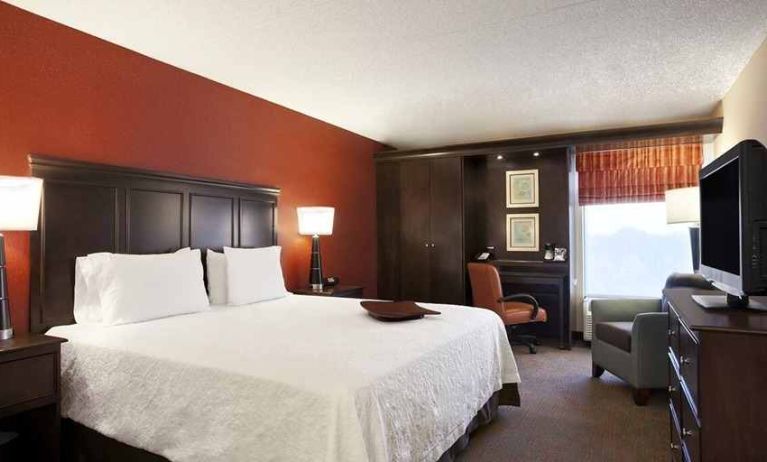 luxury king bedroom with work desk and TV at Hampton Inn Chicago-Midway Airport.