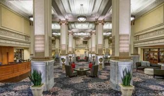 Elegant lobby area with tables and chairs perfect as workspace at the Embassy Suites by Hilton Portland-Downtown.