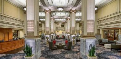 Elegant lobby area with tables and chairs perfect as workspace at the Embassy Suites by Hilton Portland-Downtown.