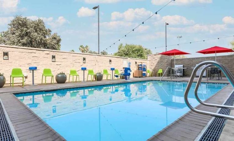 beautiful and large outdoor pool with colorful seating at Home2 Suites by Hilton West Sacramento.