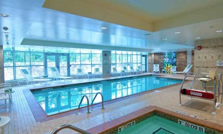 beautiful indoor pool with seating at Hilton Garden Inn Rockville-Gaithersburg.