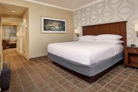 Comfortable king size bed in a hotel suite at the Embassy Suites by Hilton San Diego-La Jolla.