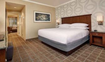 Comfortable king size bed in a hotel suite at the Embassy Suites by Hilton San Diego-La Jolla.