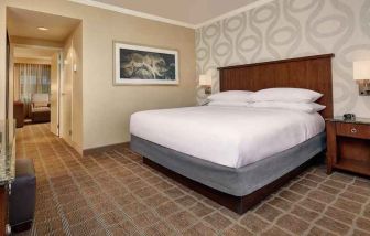 Comfortable king size bed in a hotel suite at the Embassy Suites by Hilton San Diego-La Jolla.