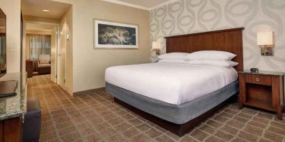 Comfortable king size bed in a hotel suite at the Embassy Suites by Hilton San Diego-La Jolla.