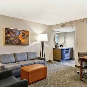 Comfortable living room with working station and sofa in a king suite at the Embassy Suites by Hilton Minneapolis-Airport.