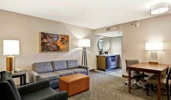 Comfortable living room with working station and sofa in a king suite at the Embassy Suites by Hilton Minneapolis-Airport.